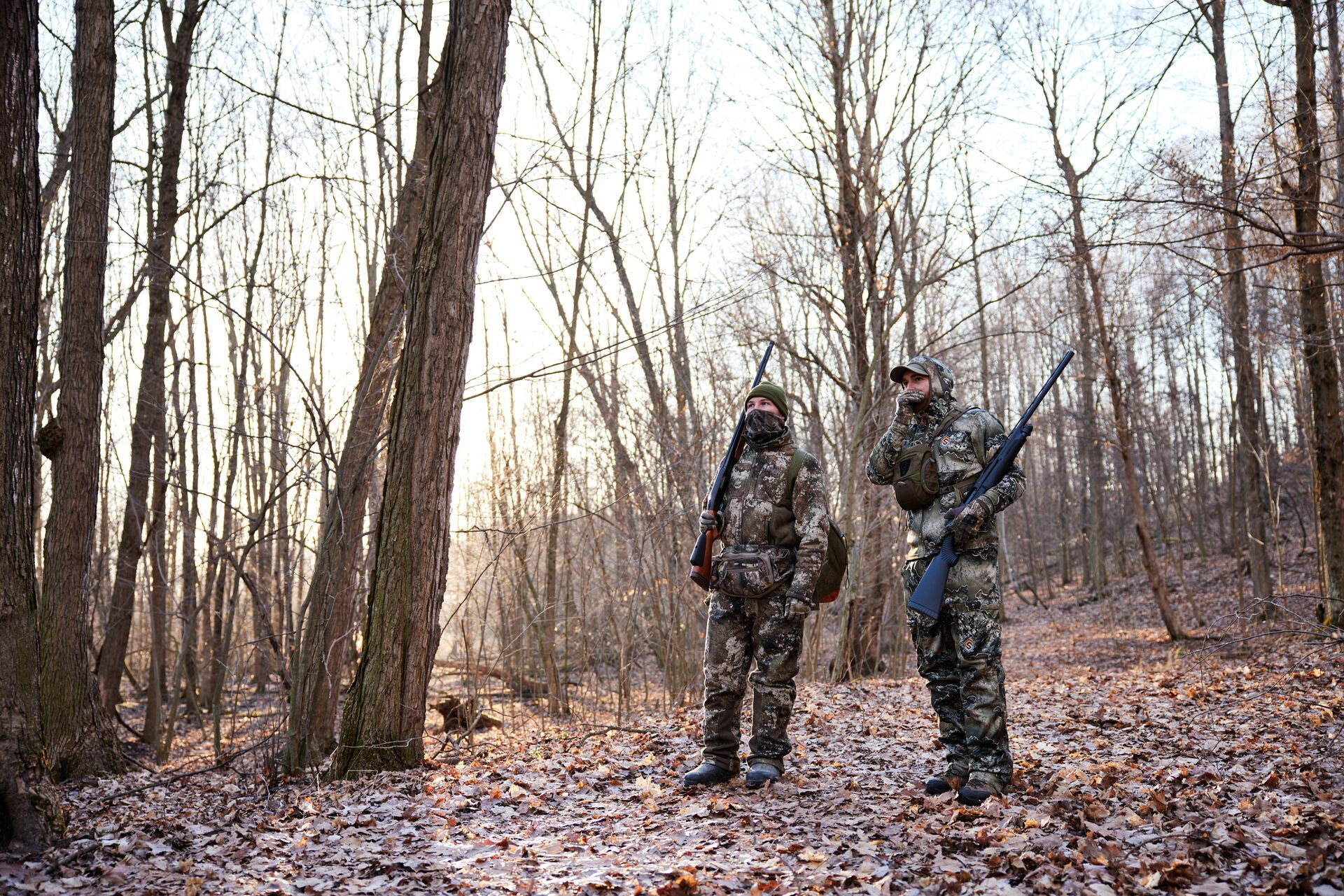 Turkey hunters walk and call in the woods, how to hunt turkey in bad weather concept. 