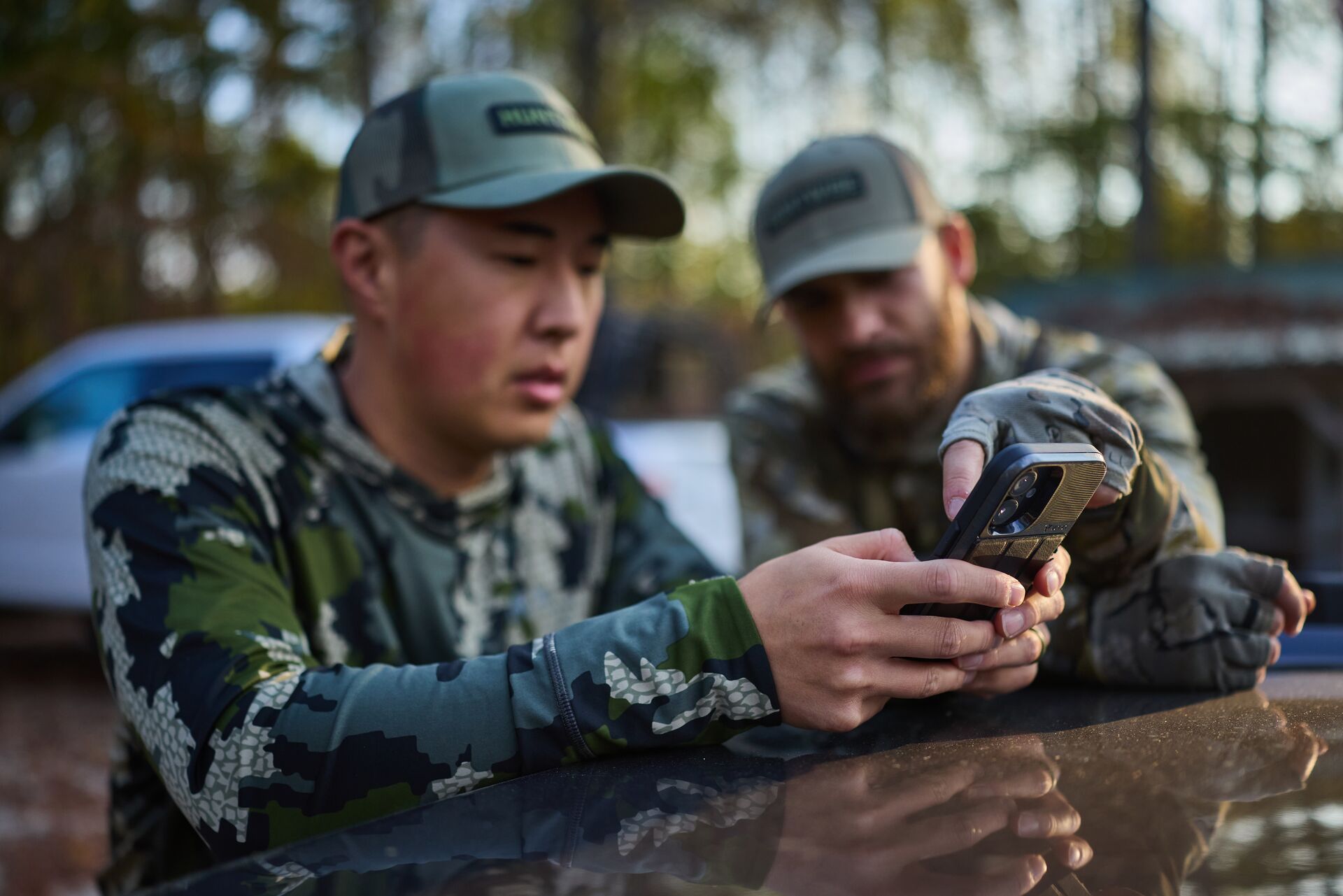 Two hunters using phone, how to report poaching concept. 