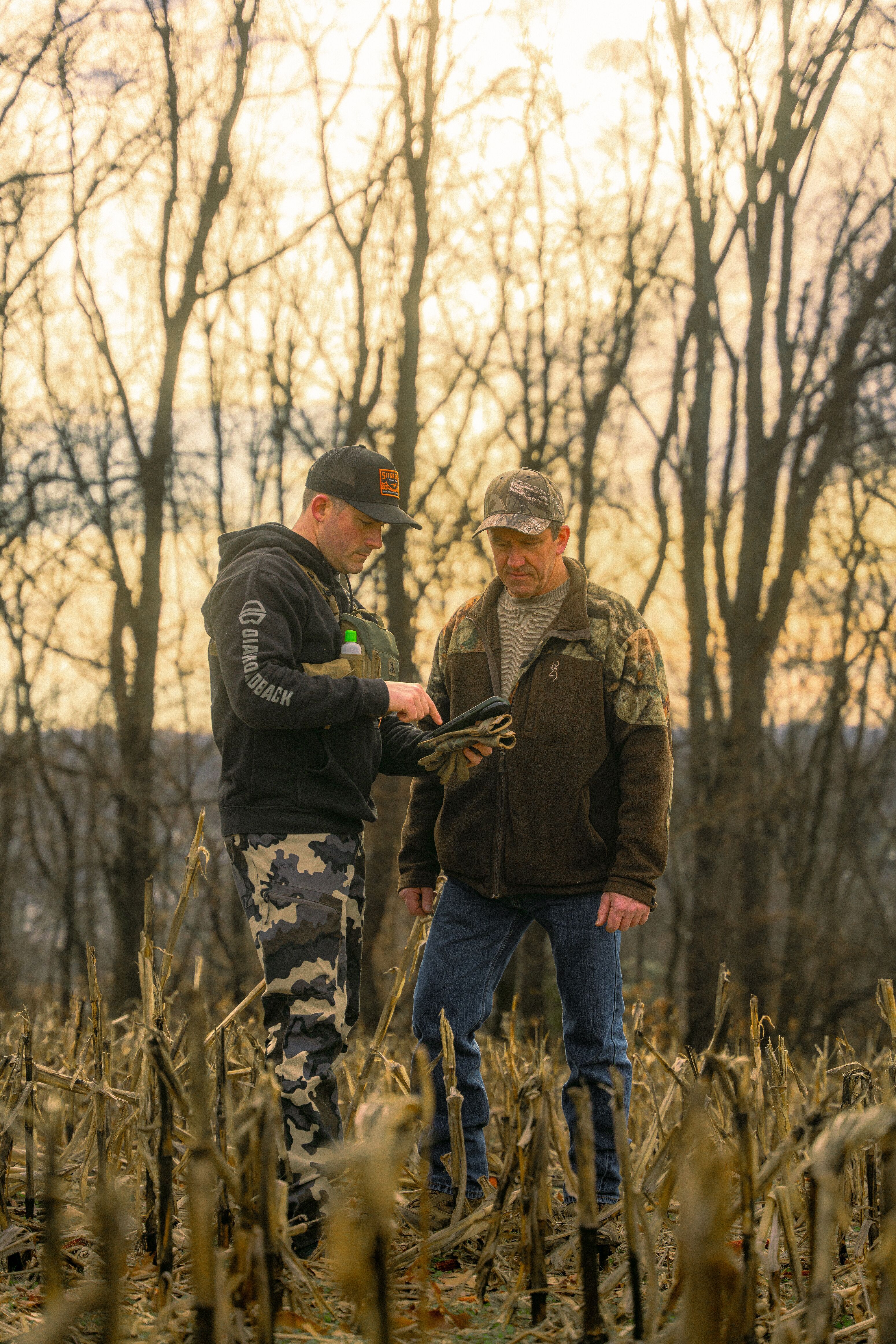FGBLOG two guys in a field looking at phone, how to get permission to hunt private land concept. 