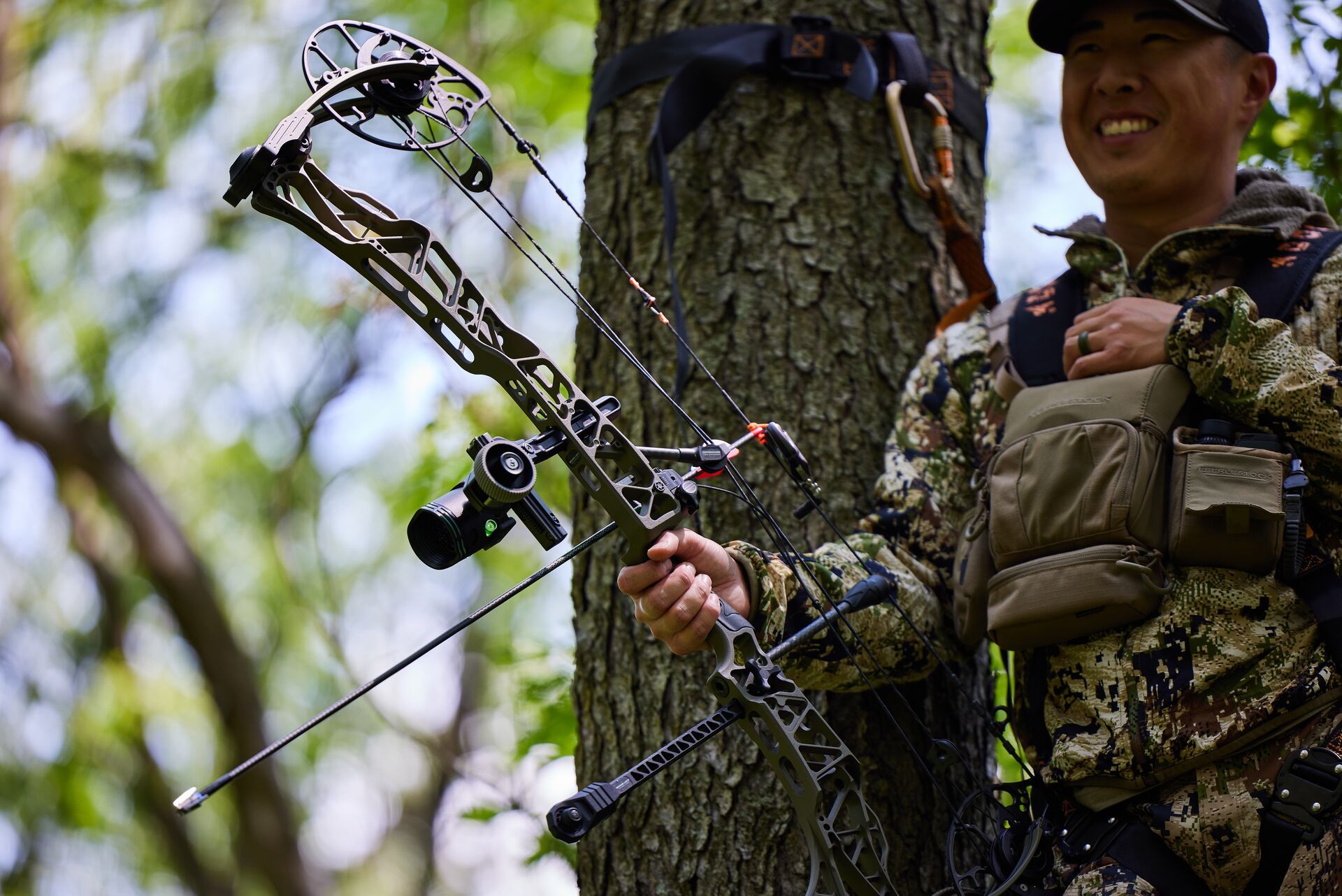 A smiling hunter in camo with a bow, deer hunting season NY concept. 