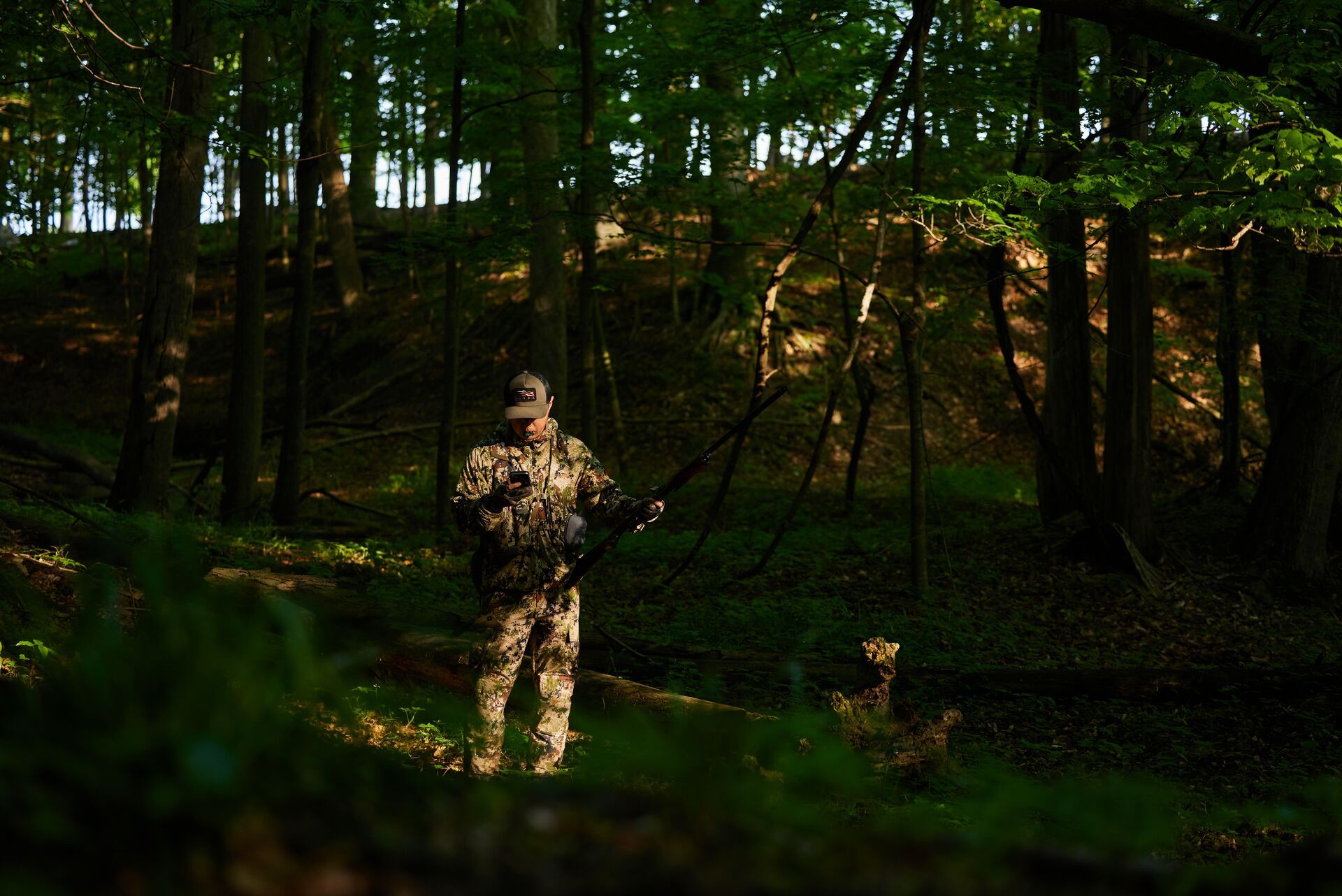 A hunter uses the HuntWise app in the woods, Florida hunting concept. 