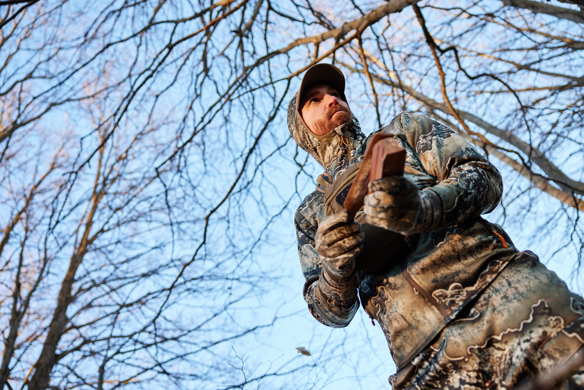 A hunter in camo uses a turkey call, hunt Osceola turkey concept. 