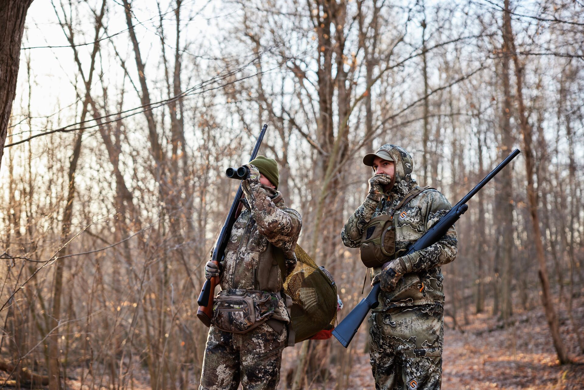 Two hunters dressed in camo with gear for turkey hunting, hunting Eastern turkey concept.