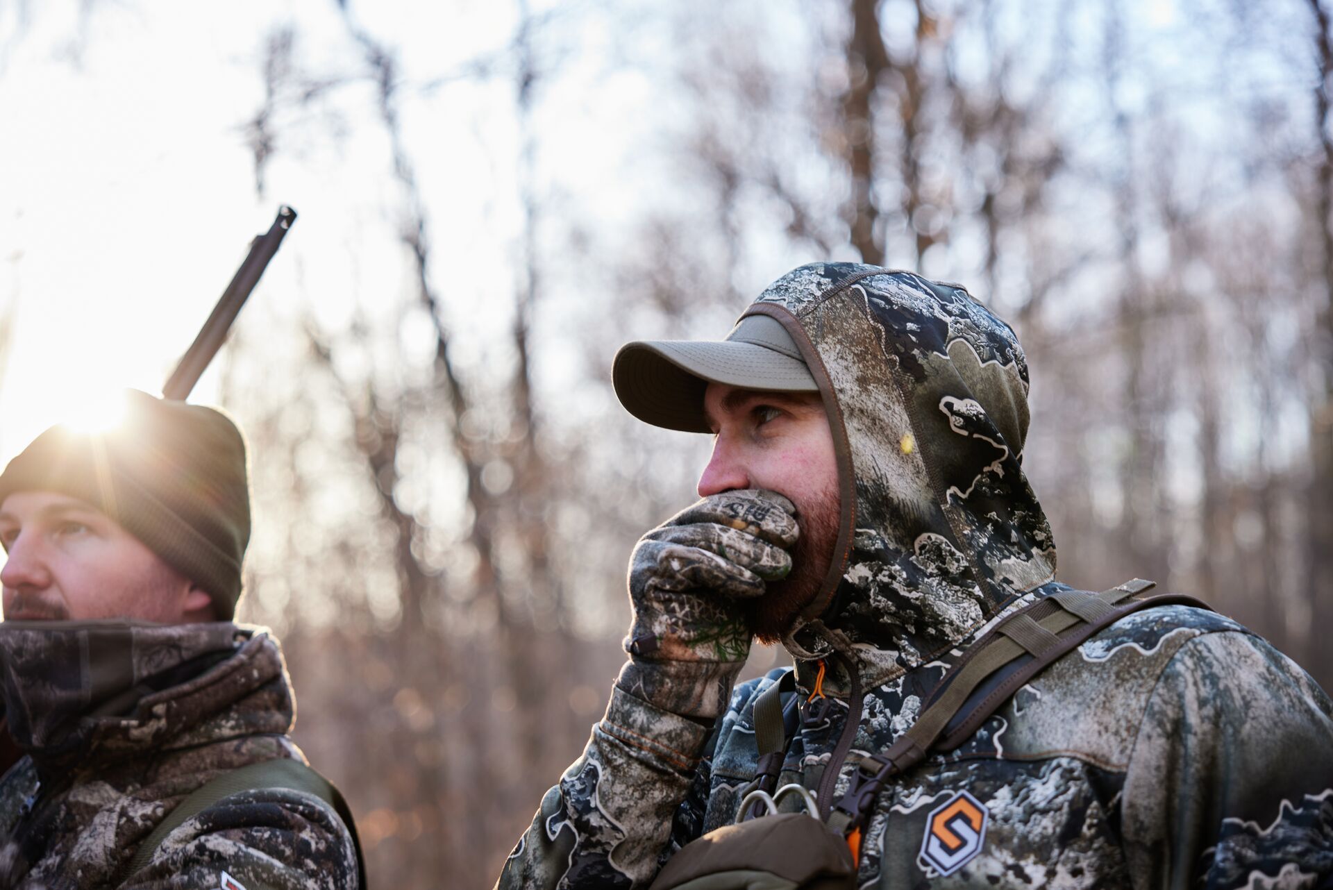 Two hunters in camo calling for turkeys, understanding wild vs heritage turkey concept. 