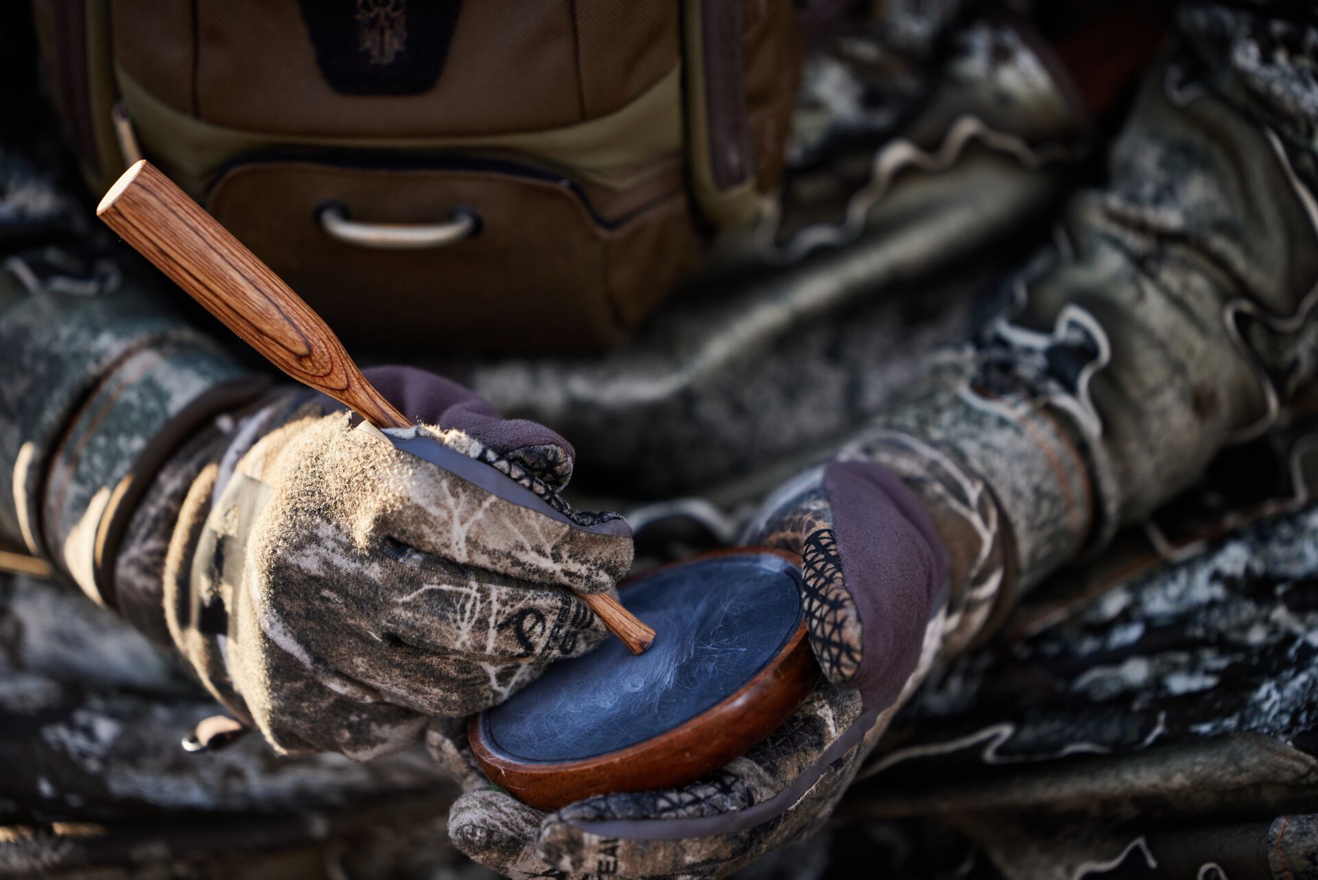 Close-up of a hunter's hands using a turkey call. 