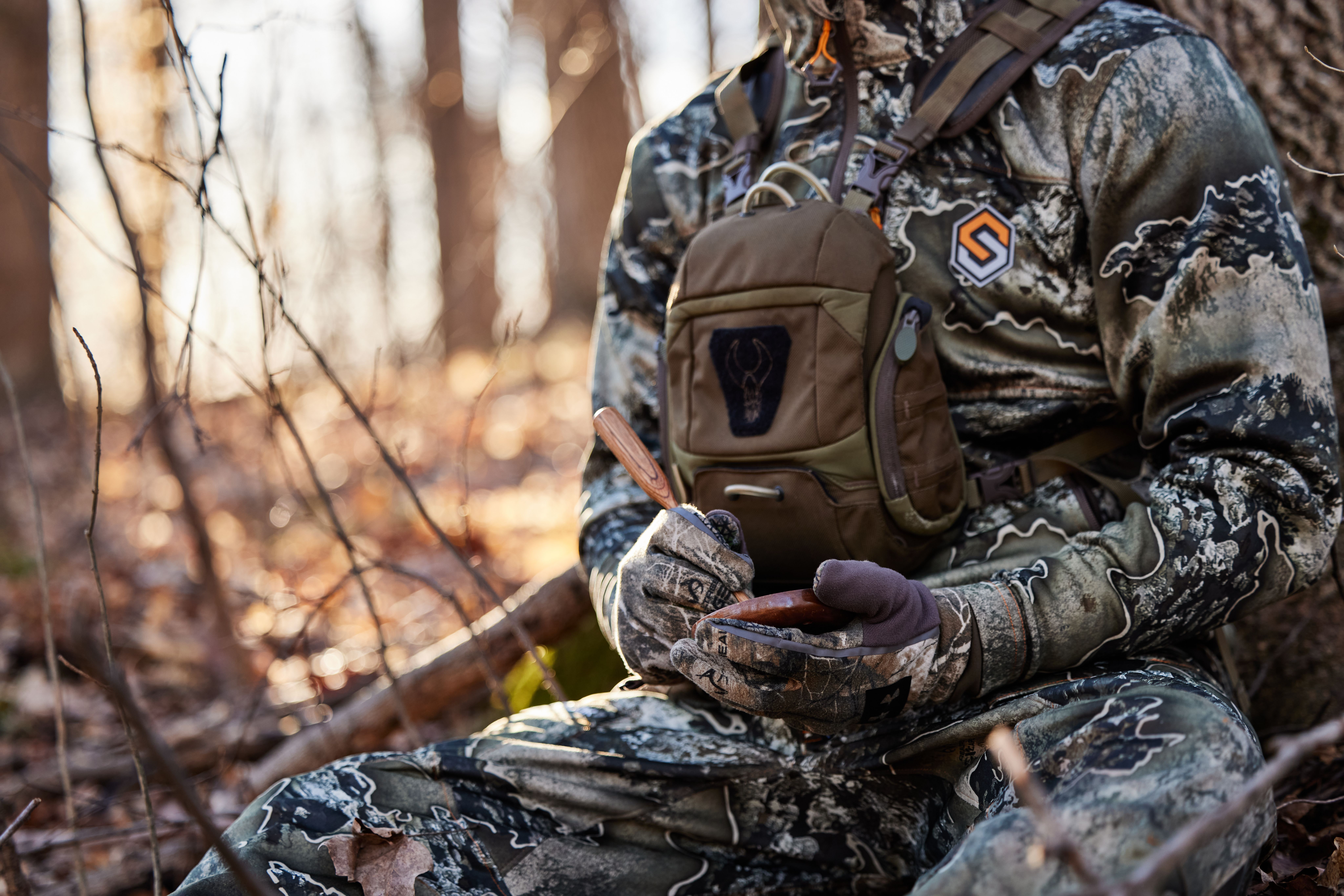A hunter with gear in the woods, essential hunting gear concept. 