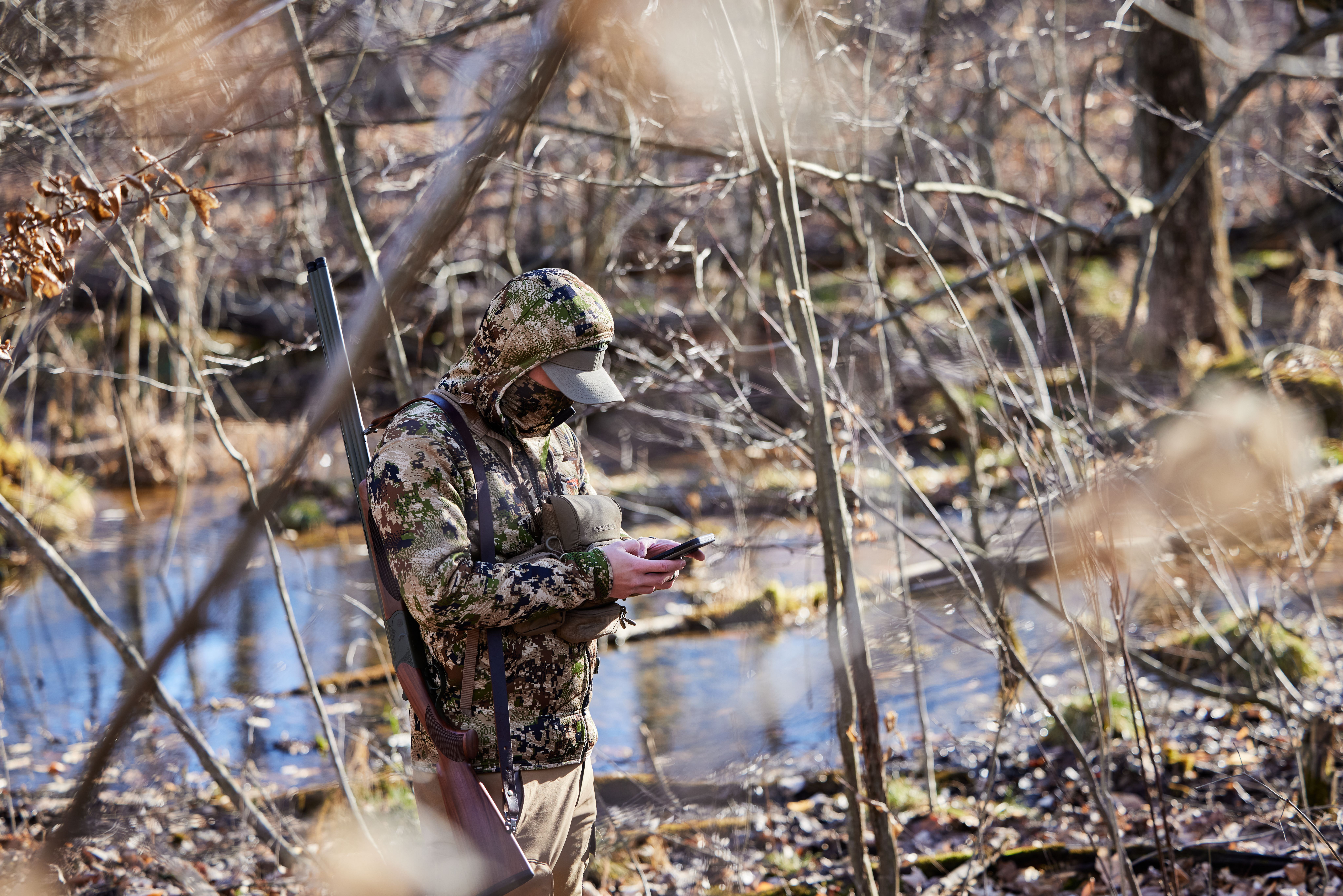 A hunter uses the HuntWise app in the field, Alabama hunting concept. 