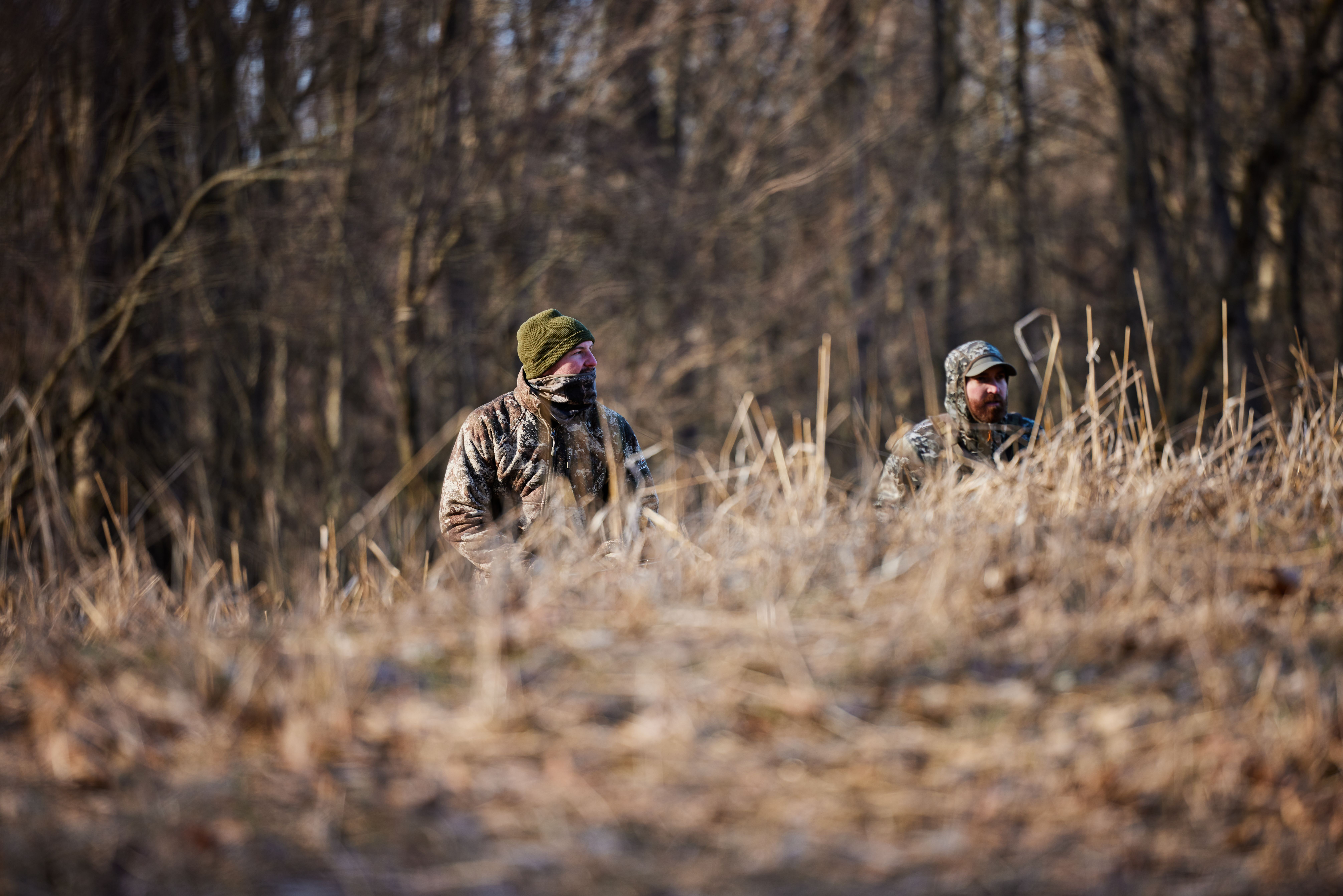 Hunters in a field, using trail cams to scout concept. 