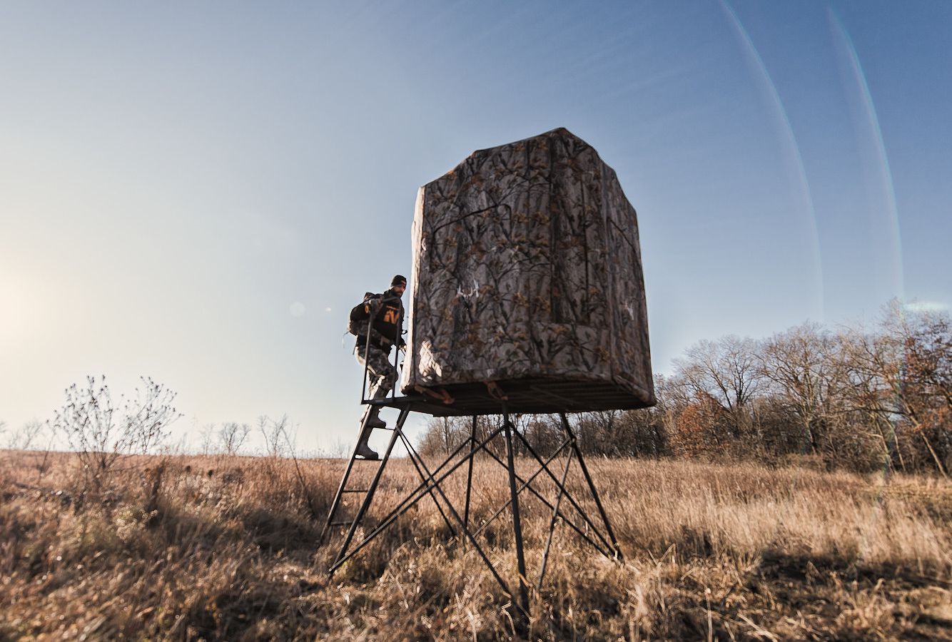 A hunter walks into a hunting blind, how to hunt whitetail in the rain concept. 