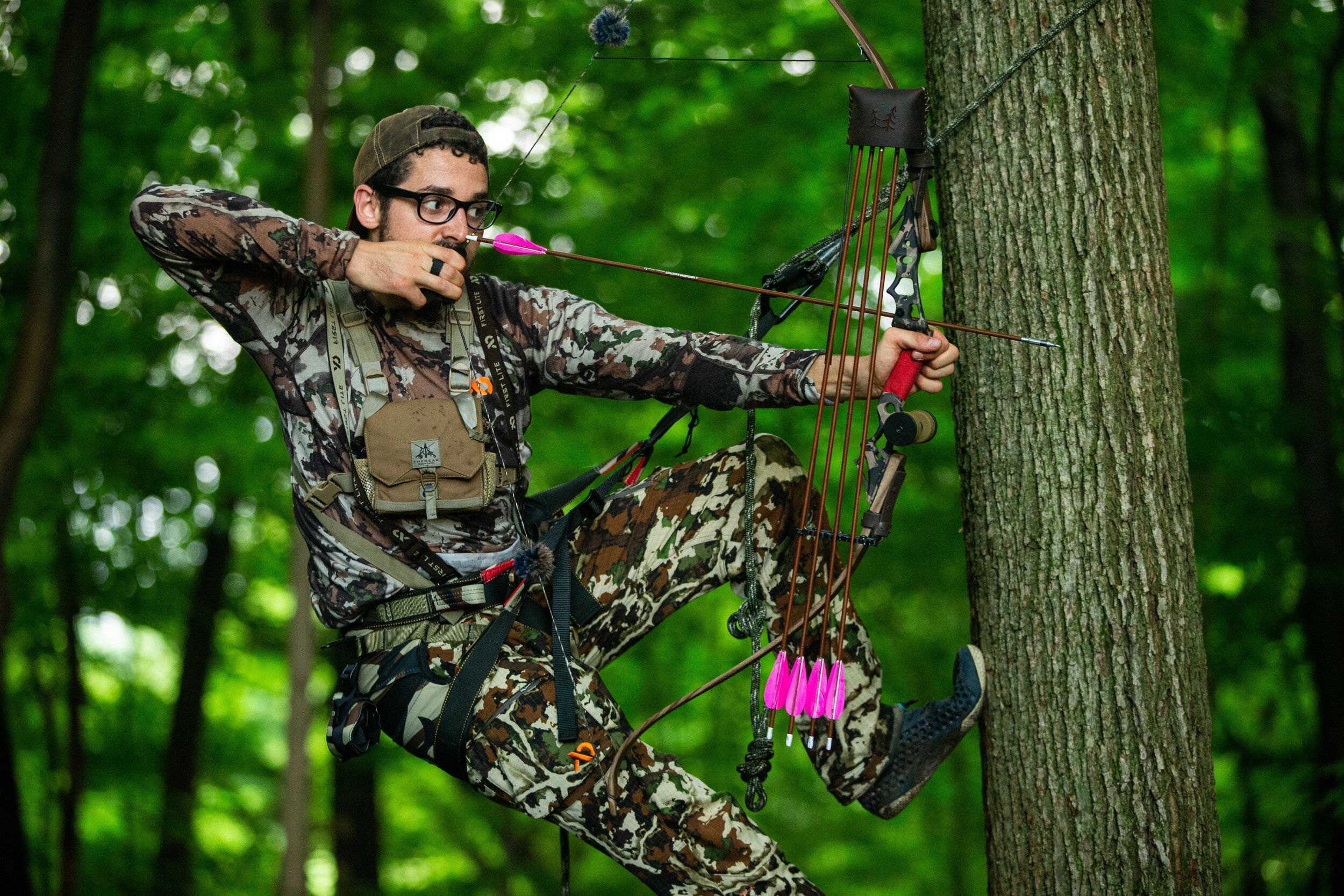 A bowhunter in a tree, finding hunting land concept. 